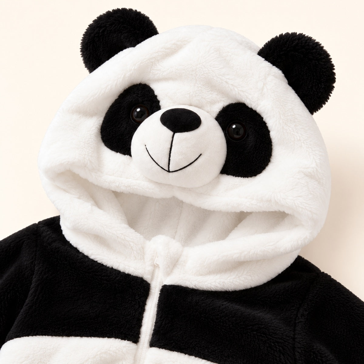 Close-up of the black and white panda hood, showing the ears, face and neckline of the romper.